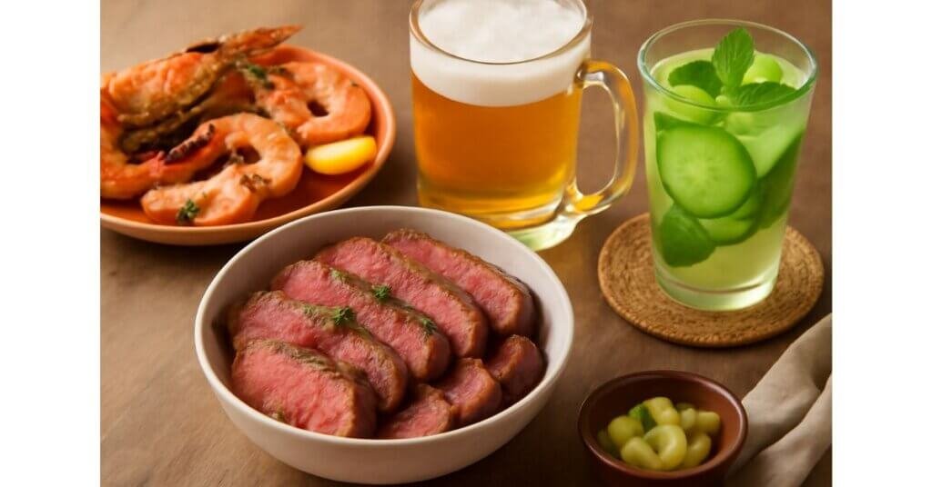 Bữa ăn với thịt bò nướng, tôm nướng, bia và nước ép dưa leo bạc hà, tượng trưng cho các thói quen ăn uống có thể dẫn đến bệnh Gút.